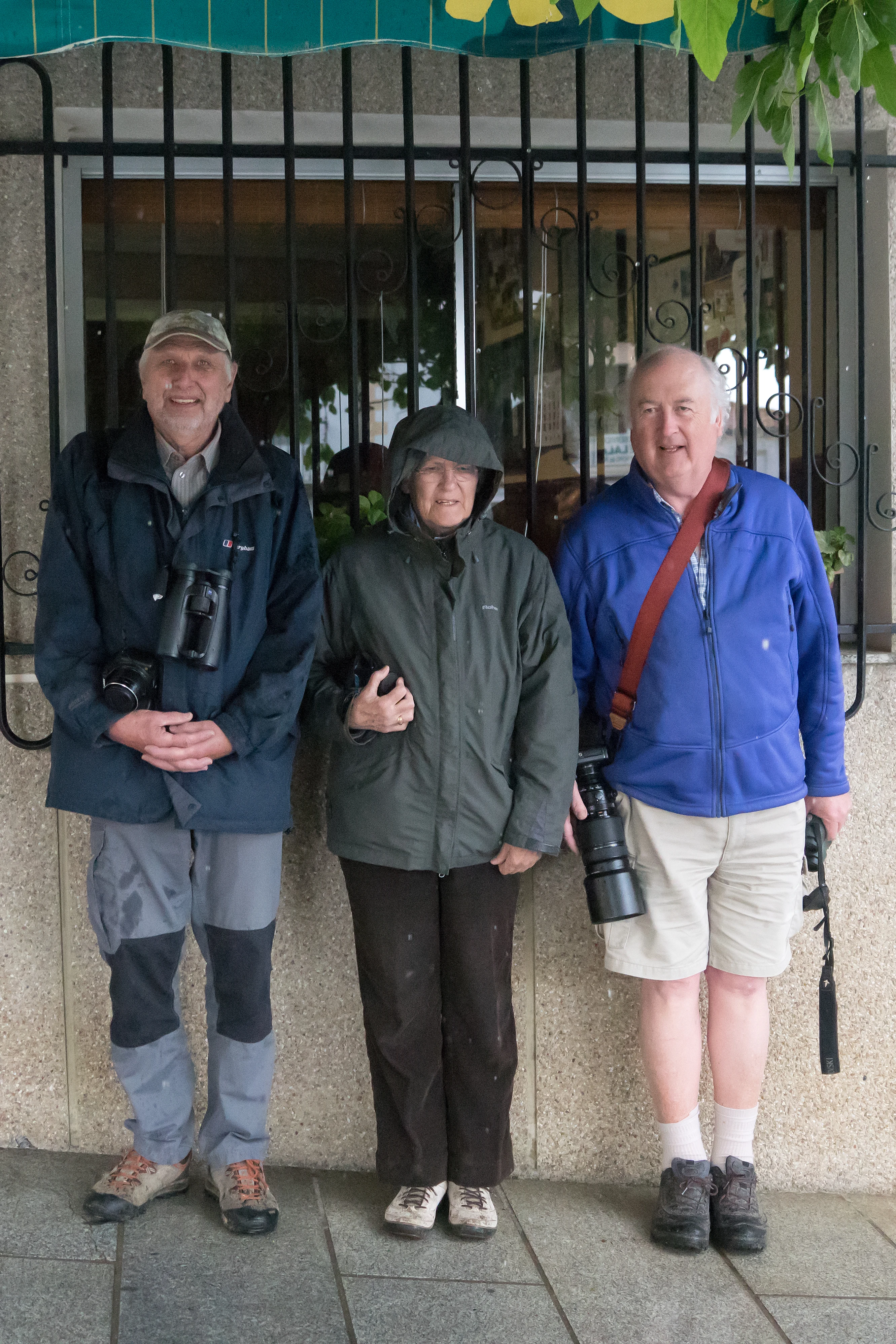 Pete, Joyce & Tony sheltering from the rain, Santa Marta de Magasca, Extremadura, Spain — photo by Jim Bennett