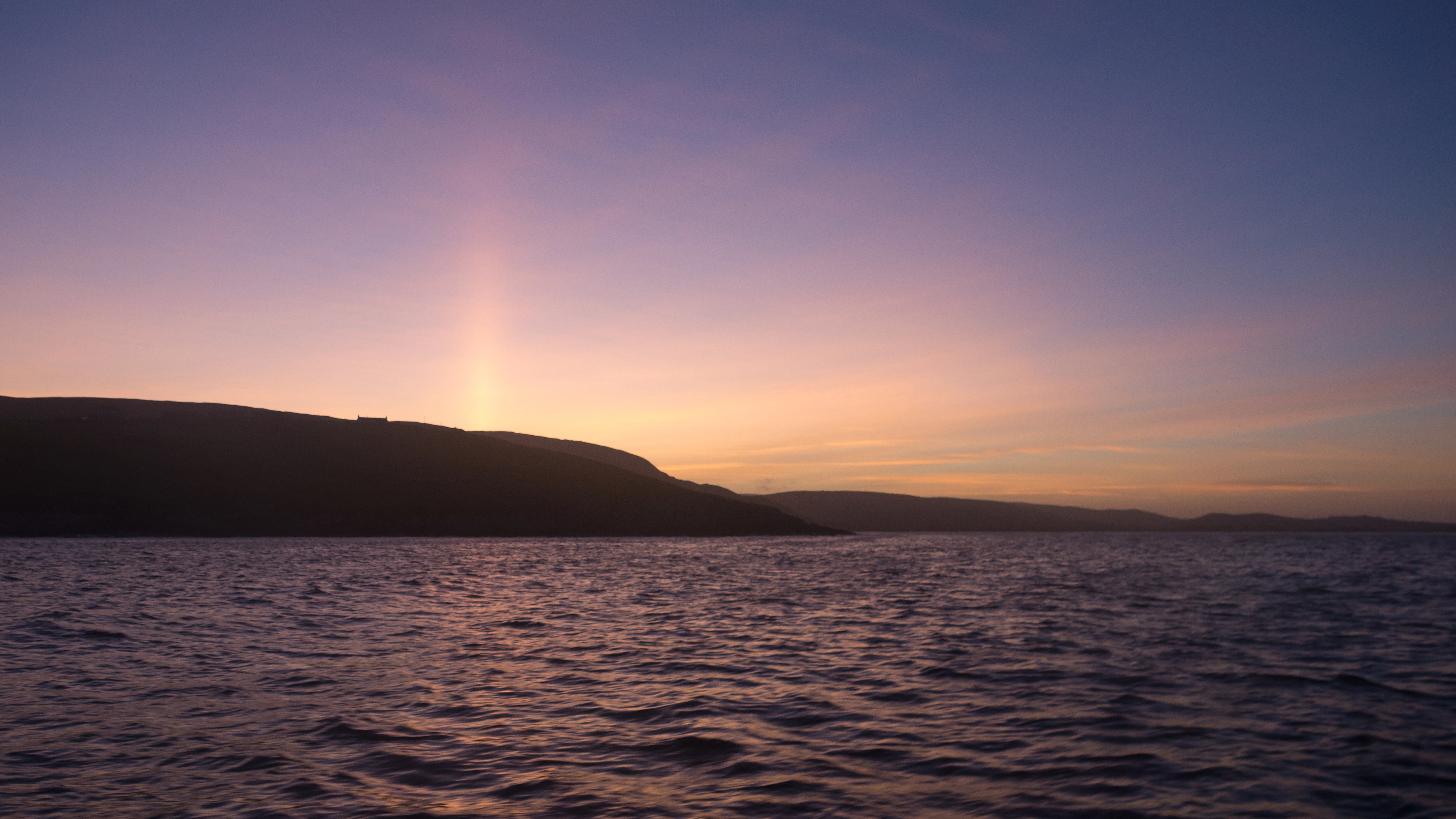 A sun pillar over Shetland, Shetland, UK — photo by Jim Bennett