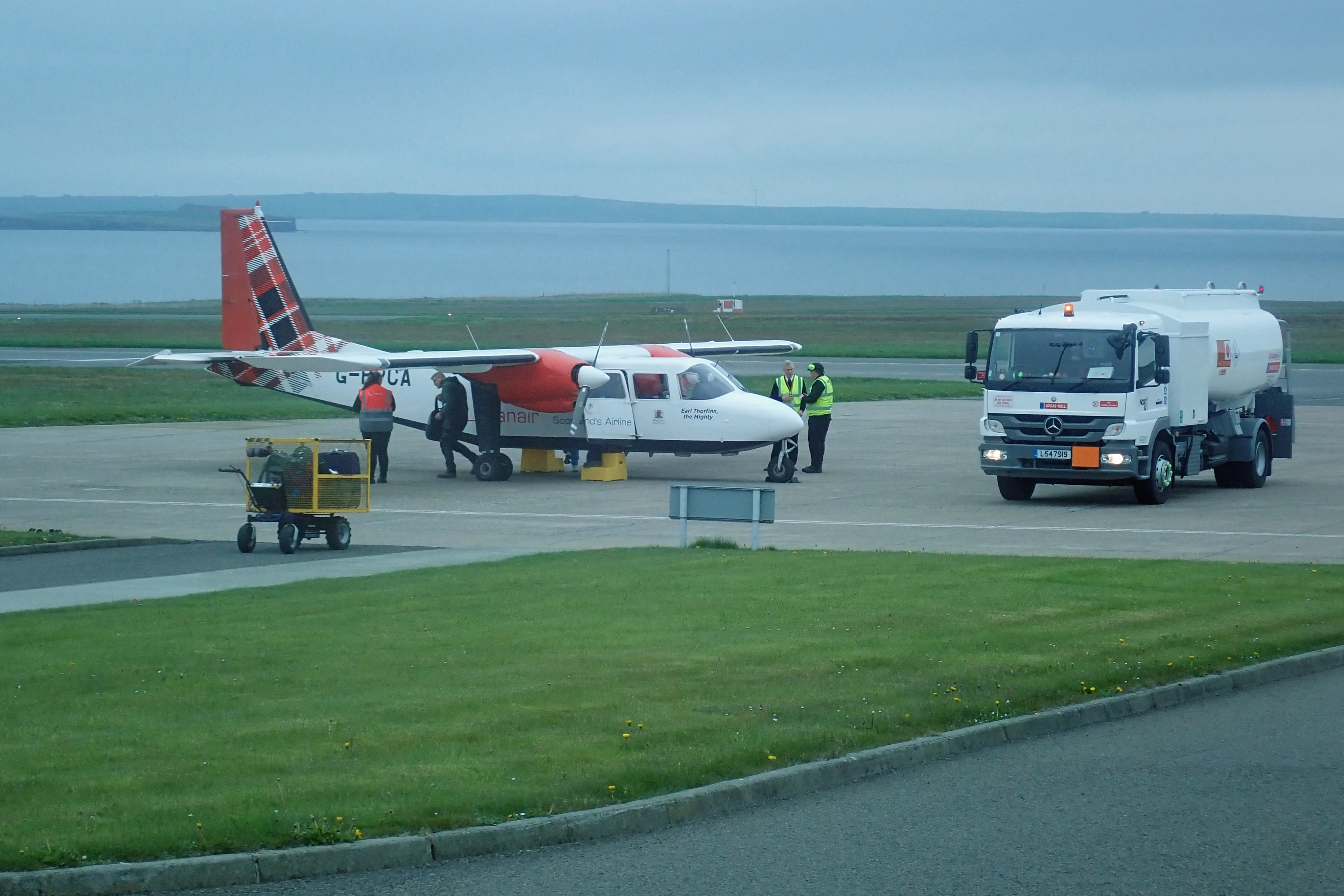 Our bags waiting while the passengers disembark, Kirkwall Airport, Orkney, UK — photo by Jim Bennett